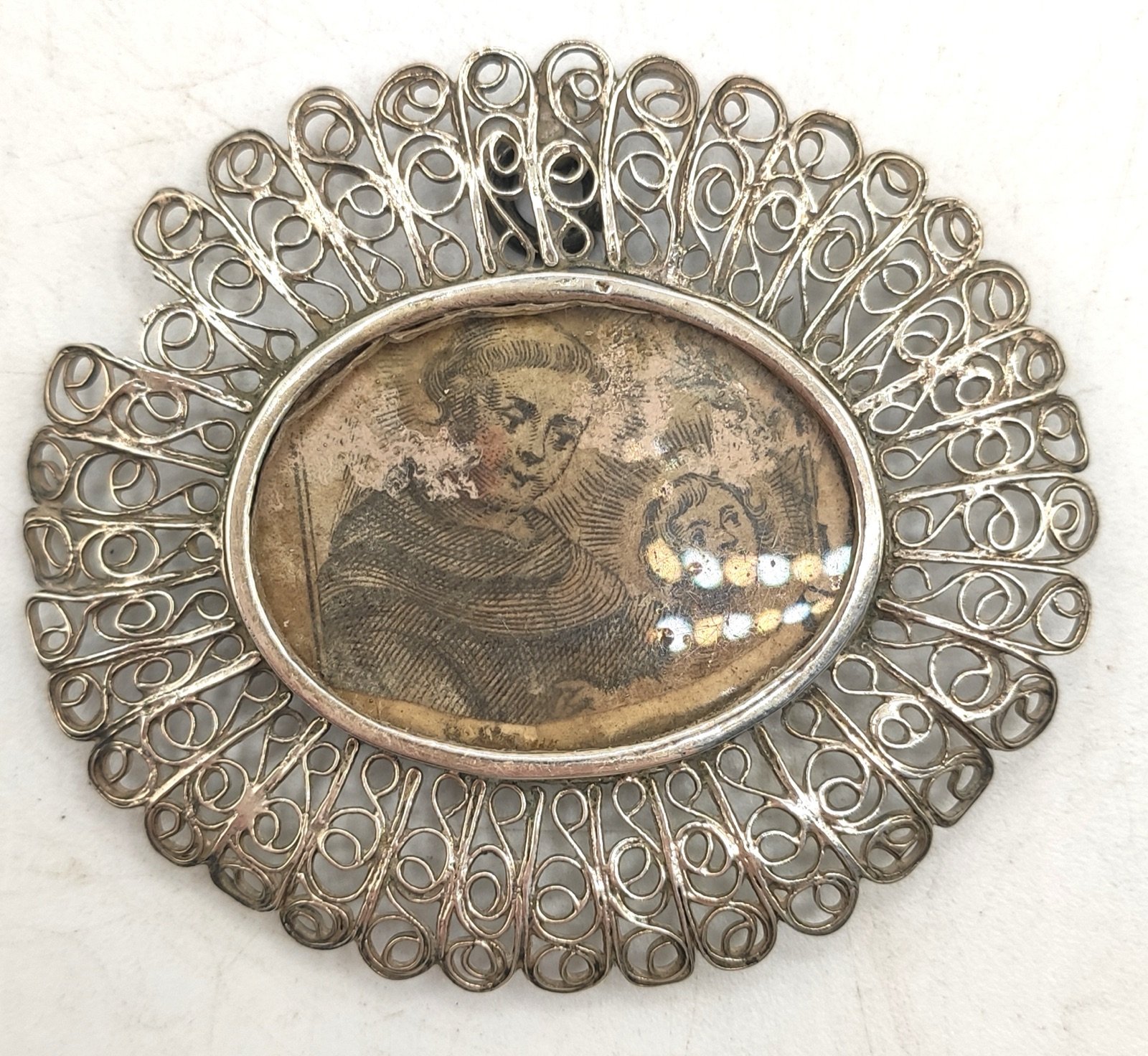 Medalla en plata con imagen de San Francisco de Asís con el niño Jesús
